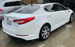 2012 Kia Optima SX in white, showcasing sport features and upgraded rims, parked in a driveway.