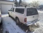 White Toyota Tacoma Xtracab parked in snowy conditions, showcasing its sturdy design and features.