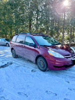 2009 Toyota Sienna LE minivan parked on snow, offering reliable family transportation for adventures.