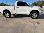 2007 Toyota Tundra SR5 4WD in white with oversized tires parked on a pavement.