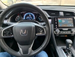 Interior view of a 2016 Honda Civic EX with dashboard and steering wheel, showing low mileage and modern features.